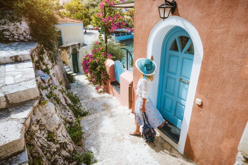 Summer vacation holiday. Travel tourist woman on vacation in Greece. Traditional Mediterranean house