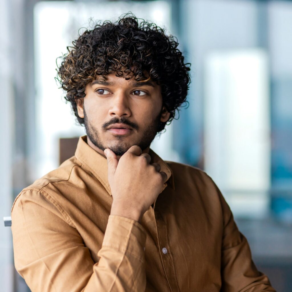 Thoughtful professional man in a modern office contemplating next business move